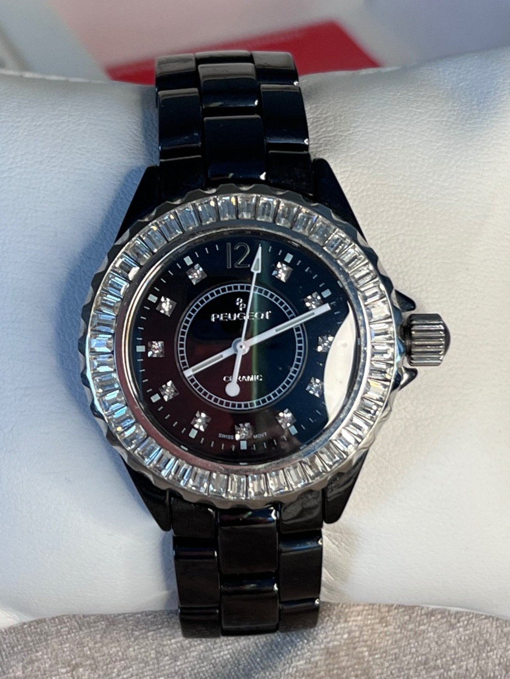 Peugeot black ceramic watch featuring a crystal-set bezel and dial markers.